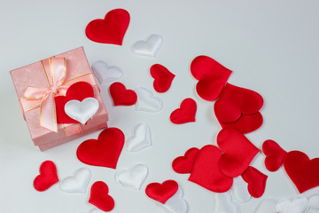 A gift in a beautiful box and hearts are red and white. Valentine's Day, International Women's Day.