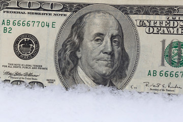 close up of one hundred dollars banknote in snow