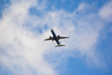 Passenger airplane landing against blue cloudy sky in Brazil