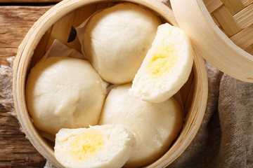 Chinese traditional steam custard buns closeup  in bamboo steamer. horizontal top view