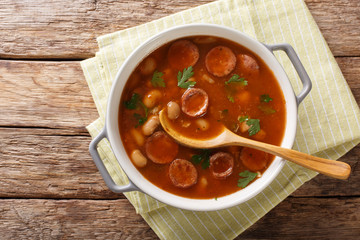 Rustic style Polish Breton beans with sausage close-up in a saucepan. Horizontal top view