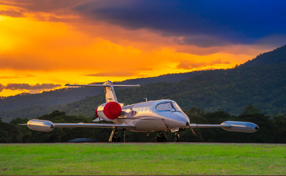 Airplane model of Bombardier Learjet 35A parking on the apron with beautiful sunset and mountain Background.