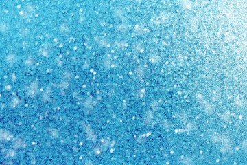 Winter blue background of snowflakes and frost. Crystals, the texture of the ice with the flare of the sun