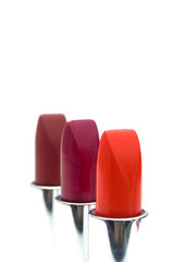 Three lipsticks isolated on a white background.