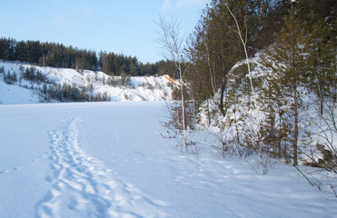 Sunny weather. Path on a snowy lake.