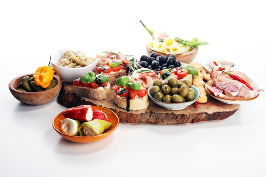 Italian antipasti wine snacks set. Cheese variety, Mediterranean olives, pickles, Prosciutto di Parma, tomatoes, artichokes