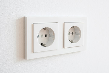 double socket, new electric plug on white wall -