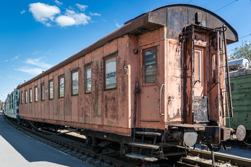 Fototapeta na wymiar old rusty passenger railway wagon with peeling paint
