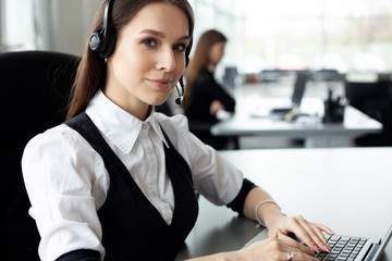 Female customer support operator with headset and smiling.