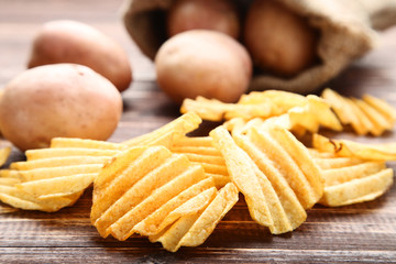 Fototapeta na wymiar Potato chips on brown wooden table