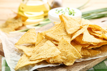 Potato chips on wooden board with sauce
