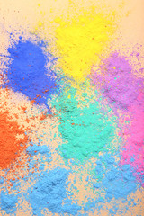 Colorful holi powders on beige background