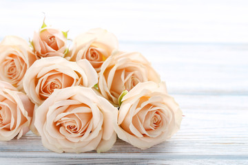 Bouquet of beige roses on white wooden table