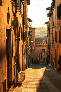 Fototapeta Romantic view to the narrow street in Tuscany, Italy at the sunset