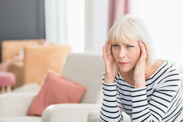Fototapeta premium Woman suffering from headache, sitting at home