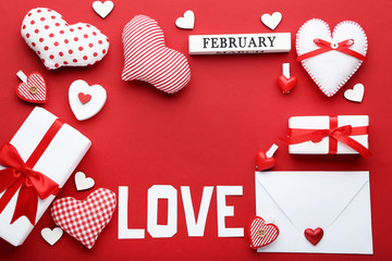 Inscription Love with hearts, gift box and envelope on red background