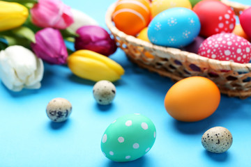 Obraz na płótnie Canvas Easter and quail eggs with tulips on blue background