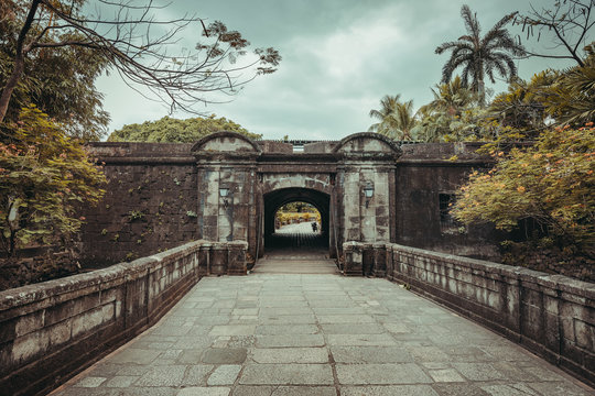 The stone bridge leading to the Fort Santiago entrance. Intramuros historic walled area. Manila, Philippine. Ancient Spanish landmark surrounded by the wild nature. The popular tourist attraction.