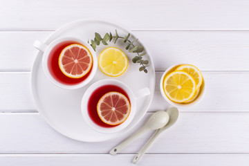 Two cups of red fruit and herbal tea with lemon slice, top view
