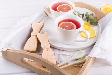 Easter bunny cookies and cup of tea. Celebration breakfast table setting. Holiday decorations.