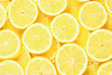 A slices of fresh juicy yellow lemons.  Texture background, pattern.