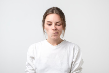 Girl looking away, having doubtful face, as if forbidden to say anything