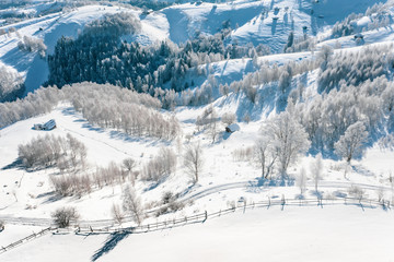 Fototapeta na wymiar Traditional Peasant houses covered in snow after a heavy snowfall in the Carpathian Mountains