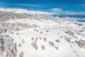 Carpathian Mountains covered in snow and the peasant village Sirnea visible in the background