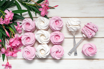 Homemade pink marshmallow from currant on a white background with pink flowers, home zephyr