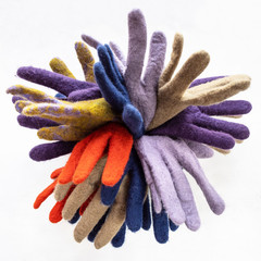bunch of new various felted gloves on gray
