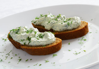 dill and cheese spread on bread decorated with dill