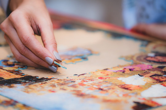 Adult And Child Solving A Jigsaw Puzzle On A Table. 