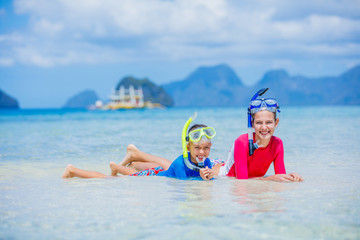 Cute girl and boy swimming on tropical beach