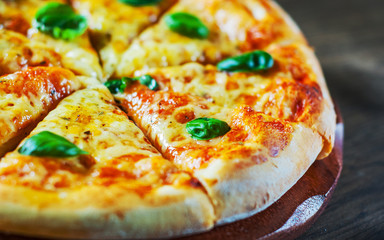 Pizza with Mozzarella cheese, Tomatoes, pepper, Spices and Fresh Basil. Italian pizza. Pizza Margherita or Margarita on wooden table background
