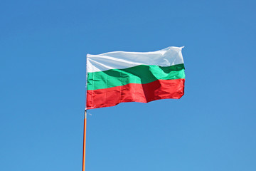 Fototapeta na wymiar Waving Flag of Bulgaria on blue sky background close up. 