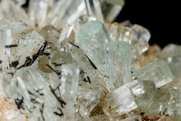 Macro mineral stone crystals Aquamarine in rock on a black background