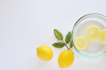 White background with lemons and lemon slices flatlay for skincare regime.