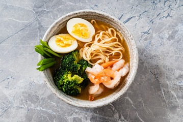 Asian soup with udon with shrimps, egg and broccoli
