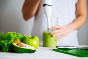 smoothie ingredients in front. woman making smoothie on backgrou