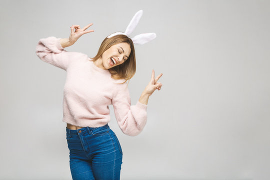 Effortless beauty. Portrait of beautiful happy young woman in bunny ears smiling while standing against white background.