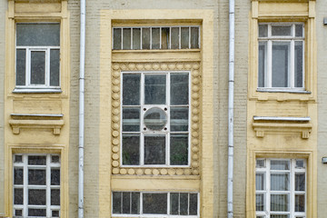 The facade of the old building in the winter under the snow