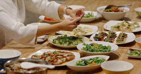 Woman take photo on her dinner at home