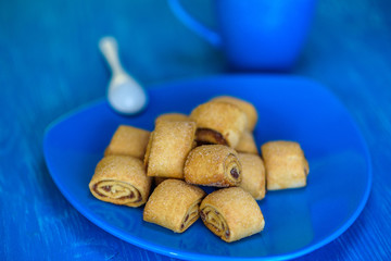 Cookies rolls with jam on a wooden turquoise background.