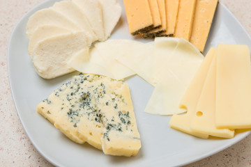 Assorted cheese sliced cheese on white plate