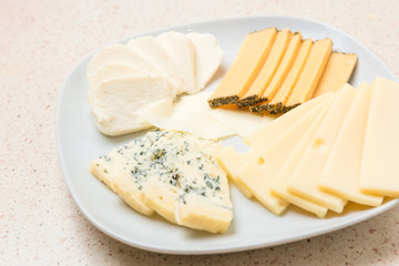 Assorted cheese sliced cheese on white plate