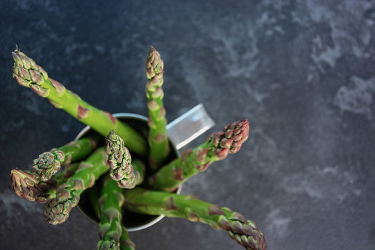 asparagus in mug on grey tabale