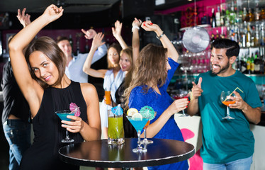 Fototapeta na wymiar Female is dancing and drinking cocktail