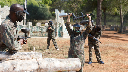 Fototapeta premium Woman playing paintball outdoors