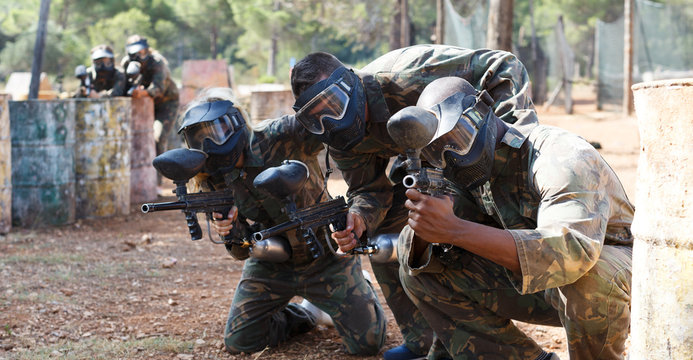 Paintball Players Aiming With Gun In Shootout Outdoors