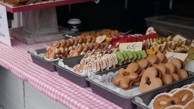 Stall with traditional colorful and festive candies at Christmas Market. Ginger bread gingerbread man and cookies pies in street shop